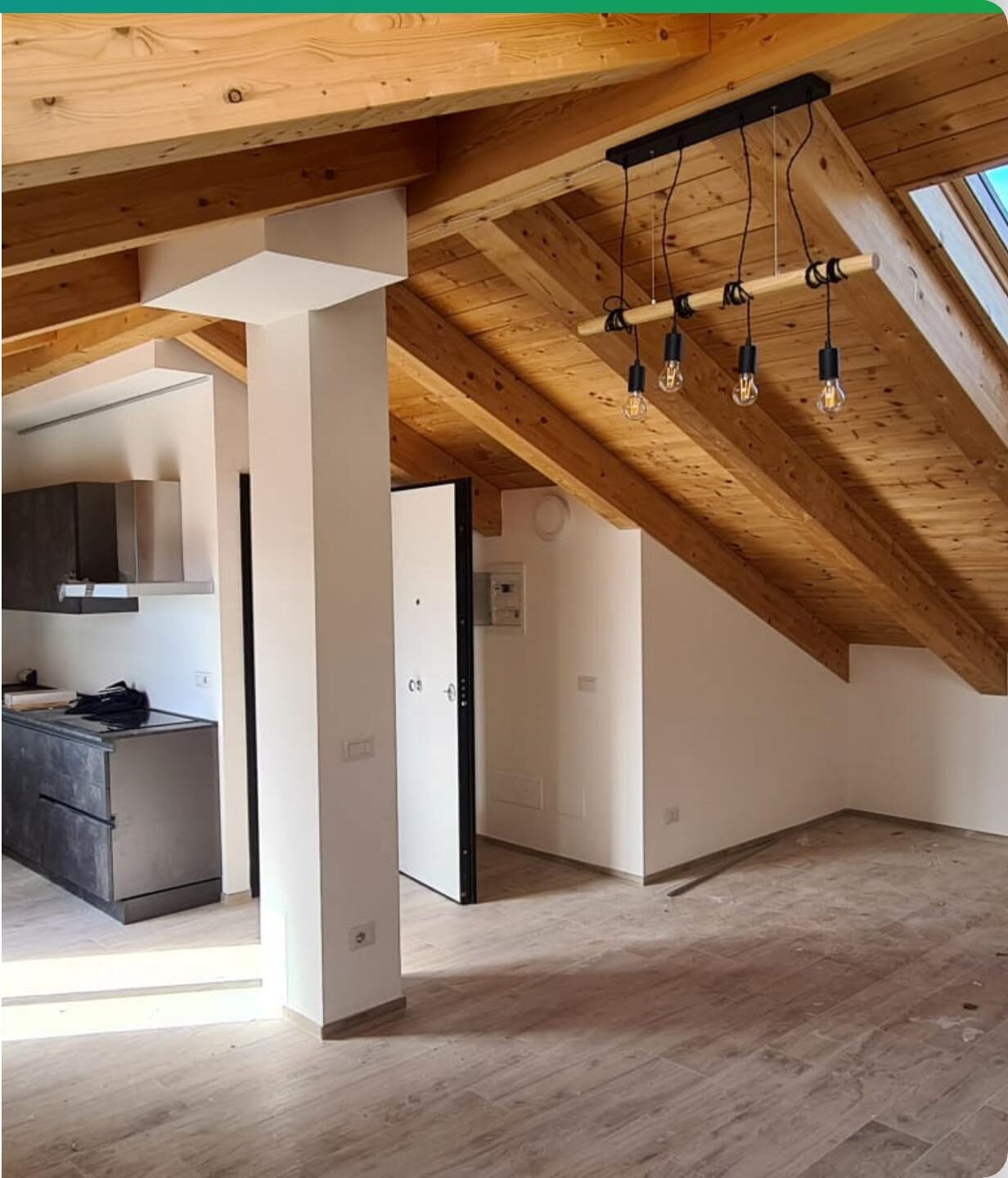 Mansarda ultimata con travi in legno a vista